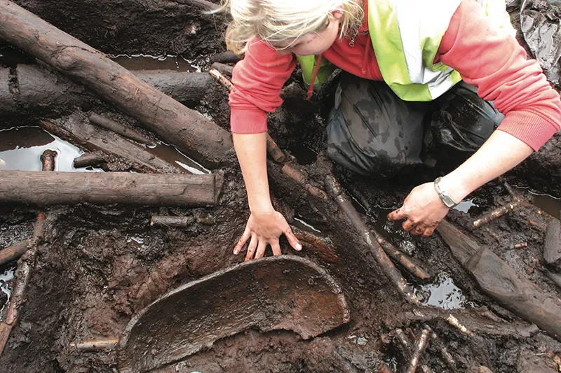 Part of a carved alder bowl being excavated by Cathy Moore